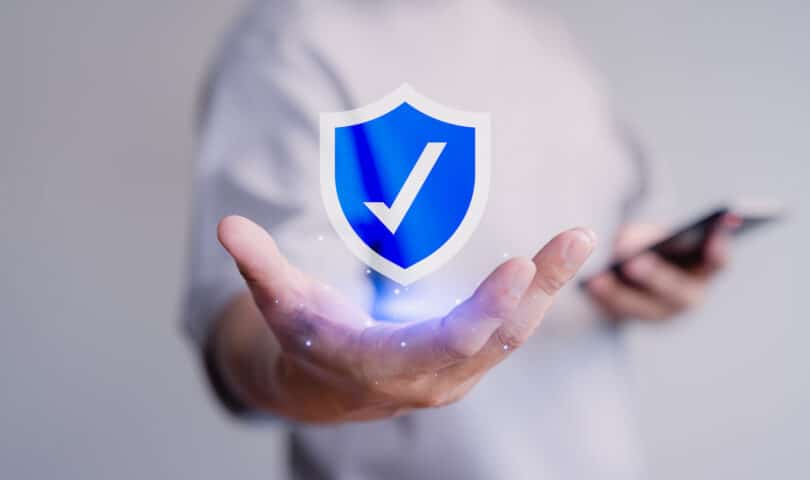 Image man holding shield with checkmark.